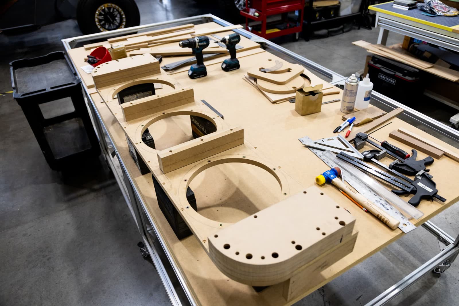 CNC cut MDF baffle panels laid out on the fabrication table for a custom subwoofer enclosure