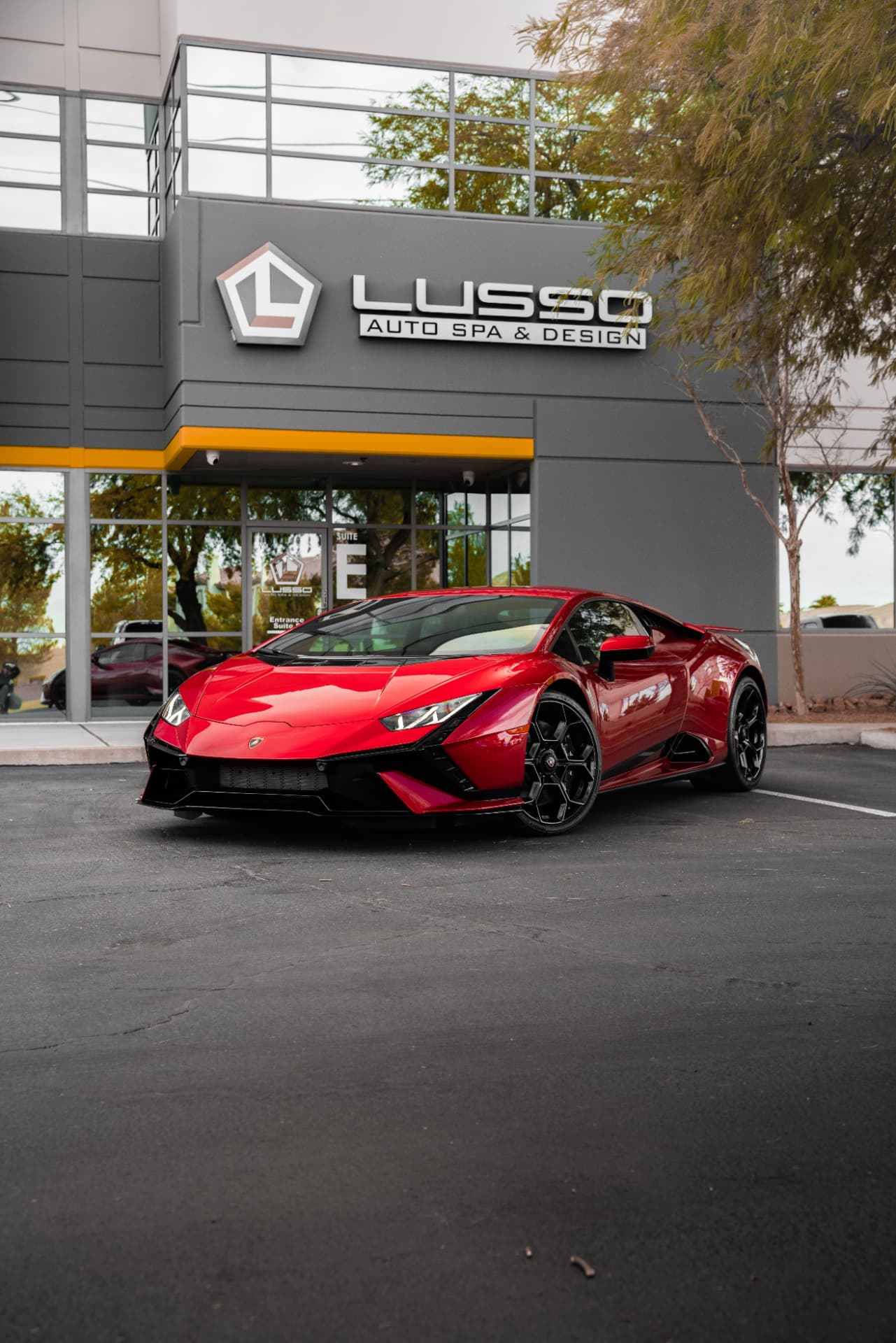 Red Lamborghini Huracan Tecnica with paint protection film outside the Lusso Auto Design shop