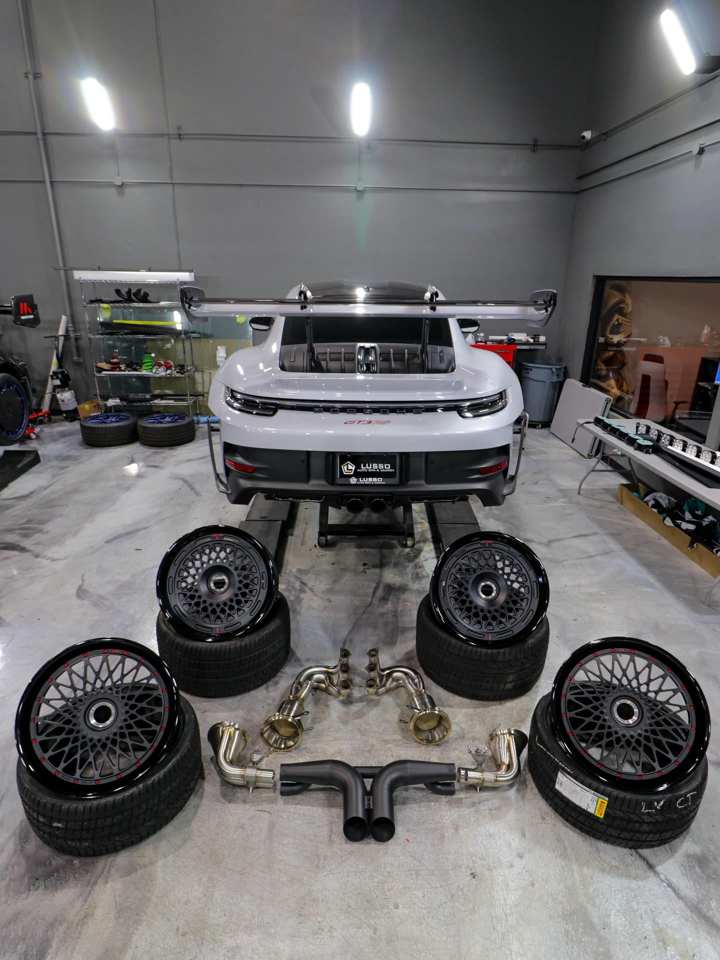 Porsche 992 GT3 RS with AL13 wheels and GMG Racing exhaust components staged on the shop floor
