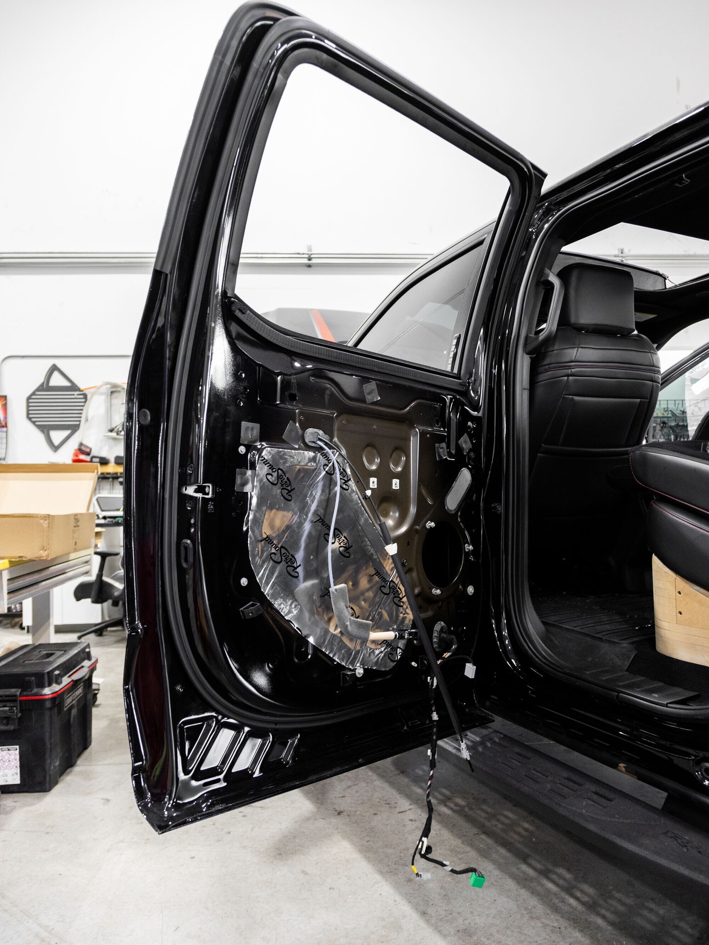 Sound deadening applied inside a black truck door during a Lusso audio install