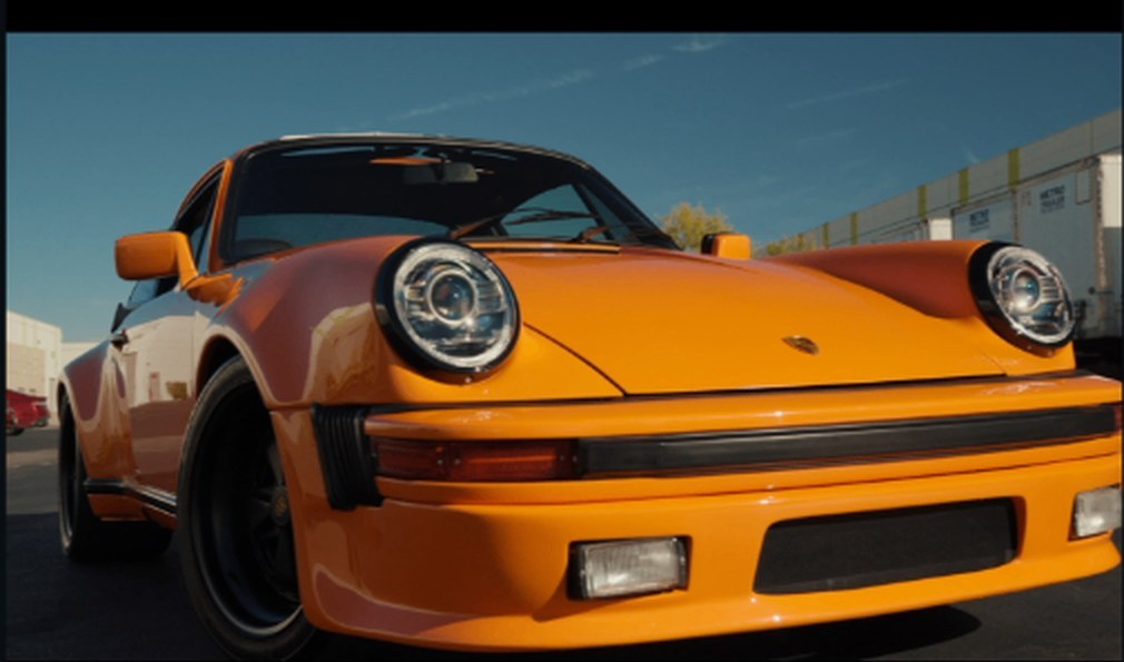 Wide-body Porsche 930 Turbo S in matte orange, front three-quarter, finished build